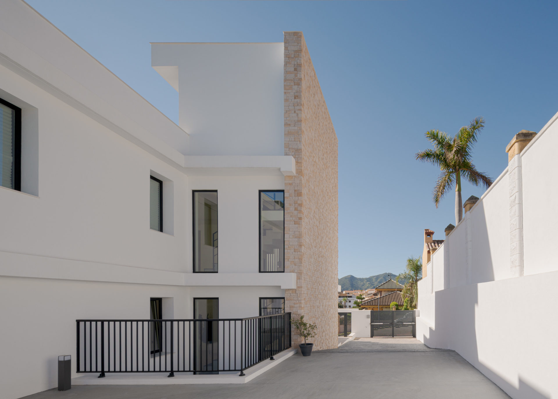 Patio extérieur avec murs blancs, escalier et palmier à Villa Venetta · maison individuelle contemporaine à Cártama (Málaga) · Klic Arquitectos