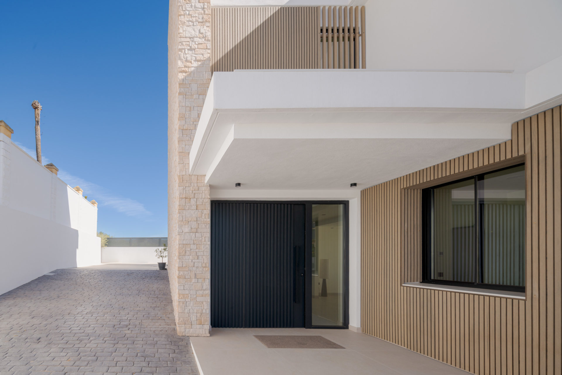 Entrée principale avec porte et lattis de bois à Villa Venetta · maison individuelle contemporaine à Cártama (Málaga) · Klic Arquitectos