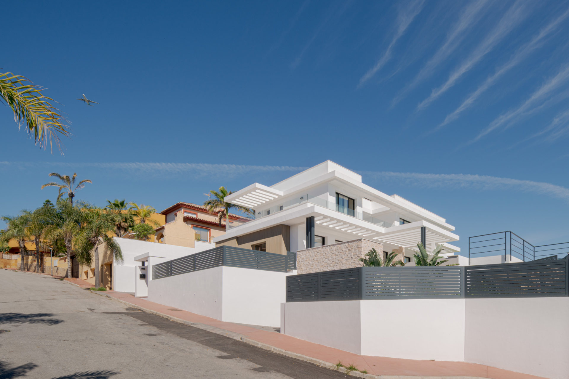 Vue latérale avec palmiers et rue de Villa Venetta · maison individuelle contemporaine à Cártama (Málaga) conçue par Klic Arquitectos