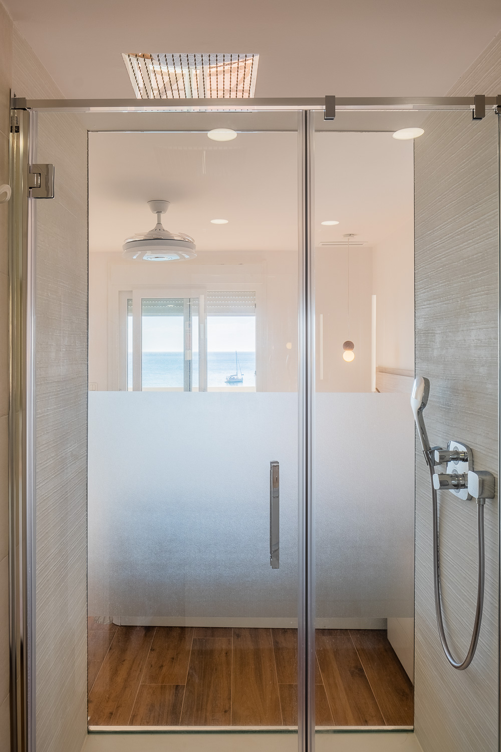 Ducha divisoria con mampara de Casa T&A, reforma con interiorismo en el Paseo Marítimo de Fuengirola (Málaga) por Klic Arquitectos