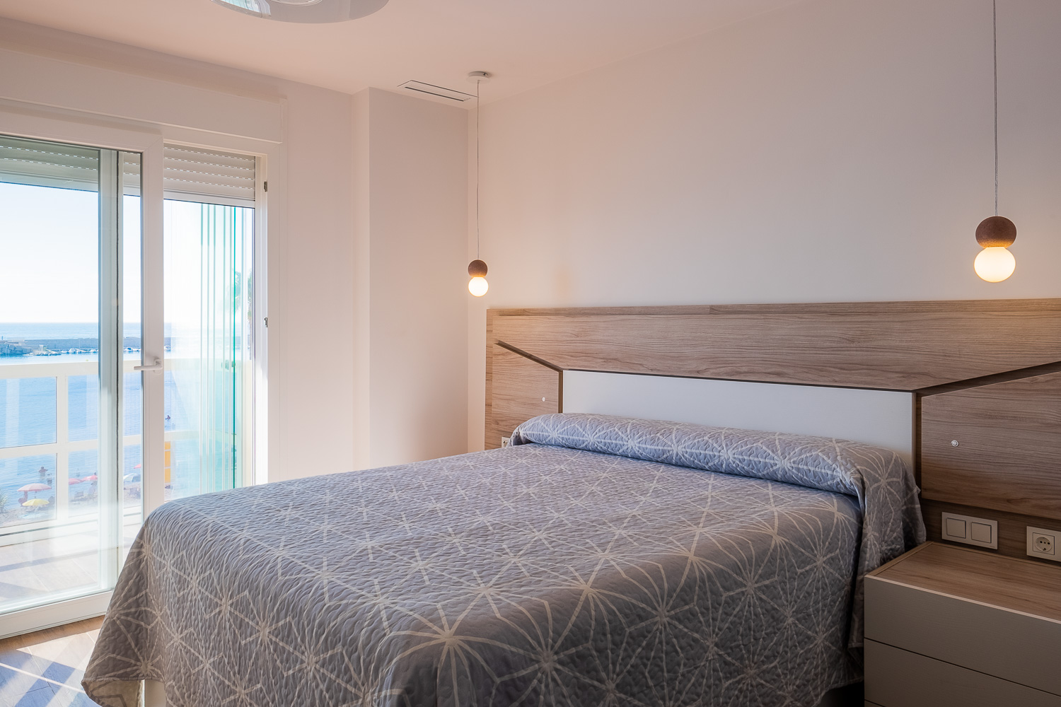 Dormitorio con cabecero a medida de Casa T&A en el Paseo Marítimo de Fuengirola (Málaga) por Klic Arquitectos