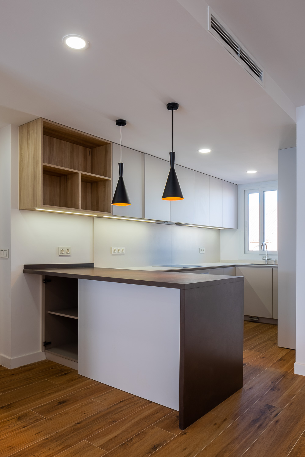 Cocina con isla central de Casa T&A, reforma con interiorismo en el Paseo Marítimo de Fuengirola (Málaga) por Klic Arquitectos