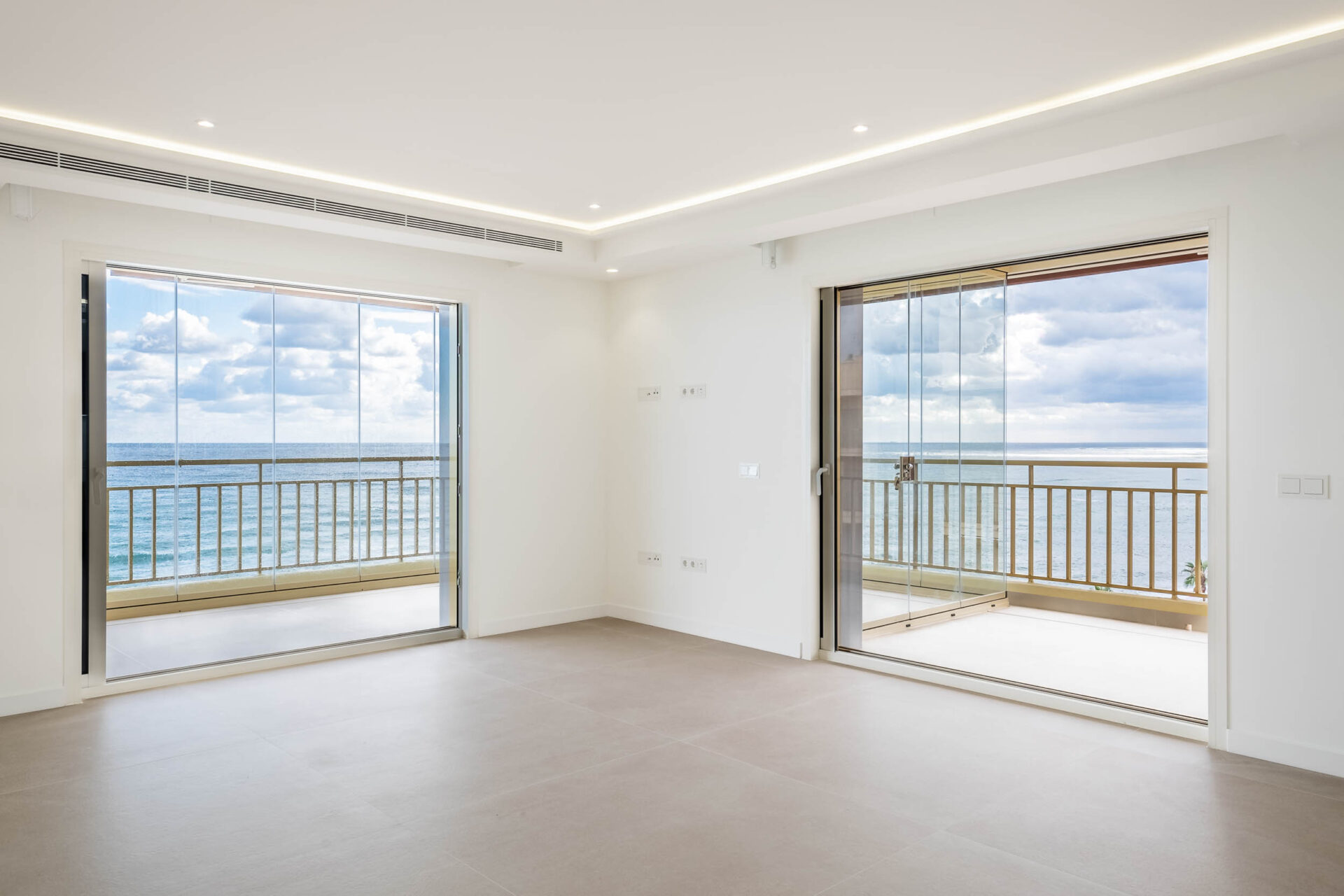 Salón principal con grandes ventanales abiertos al mar en Casa Thierry, reforma de lujo en Fuengirola (Málaga) por Klic Arquitectos