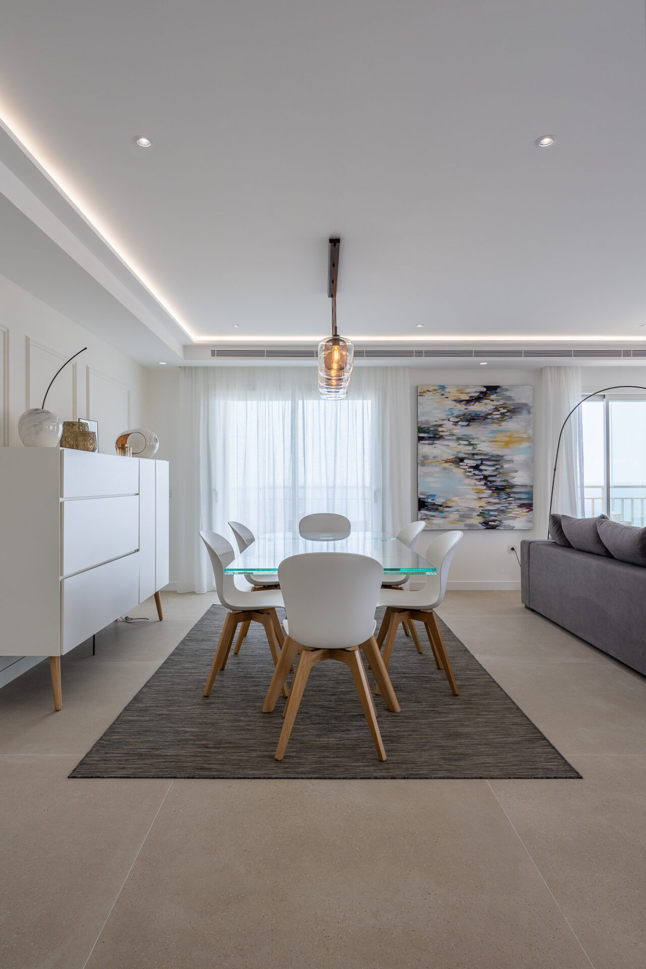 Comedor con lámpara colgante y arte mural · reforma Pº Marítimo Rey de España 3 (Fuengirola) por Klic Arquitectos