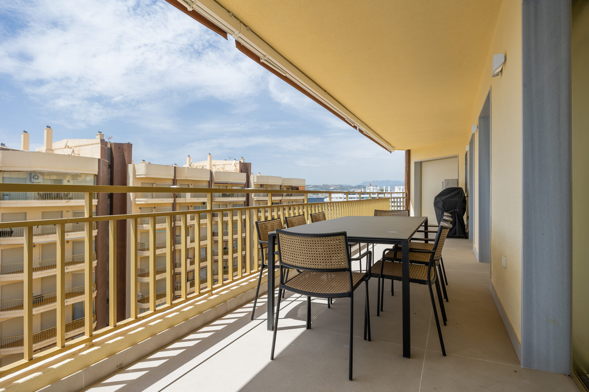 Terraza con mesa de comedor exterior y horizonte marino · reforma Pº Marítimo Rey de España 3 (Fuengirola) por Klic Arquitectos