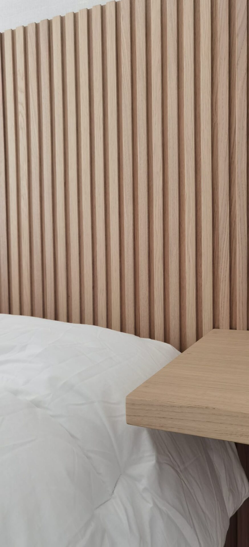 Dormitorio con cabecero revestido de lamas de madera · reforma Pº Marítimo Rey de España 3 (Fuengirola) por Klic Arquitectos
