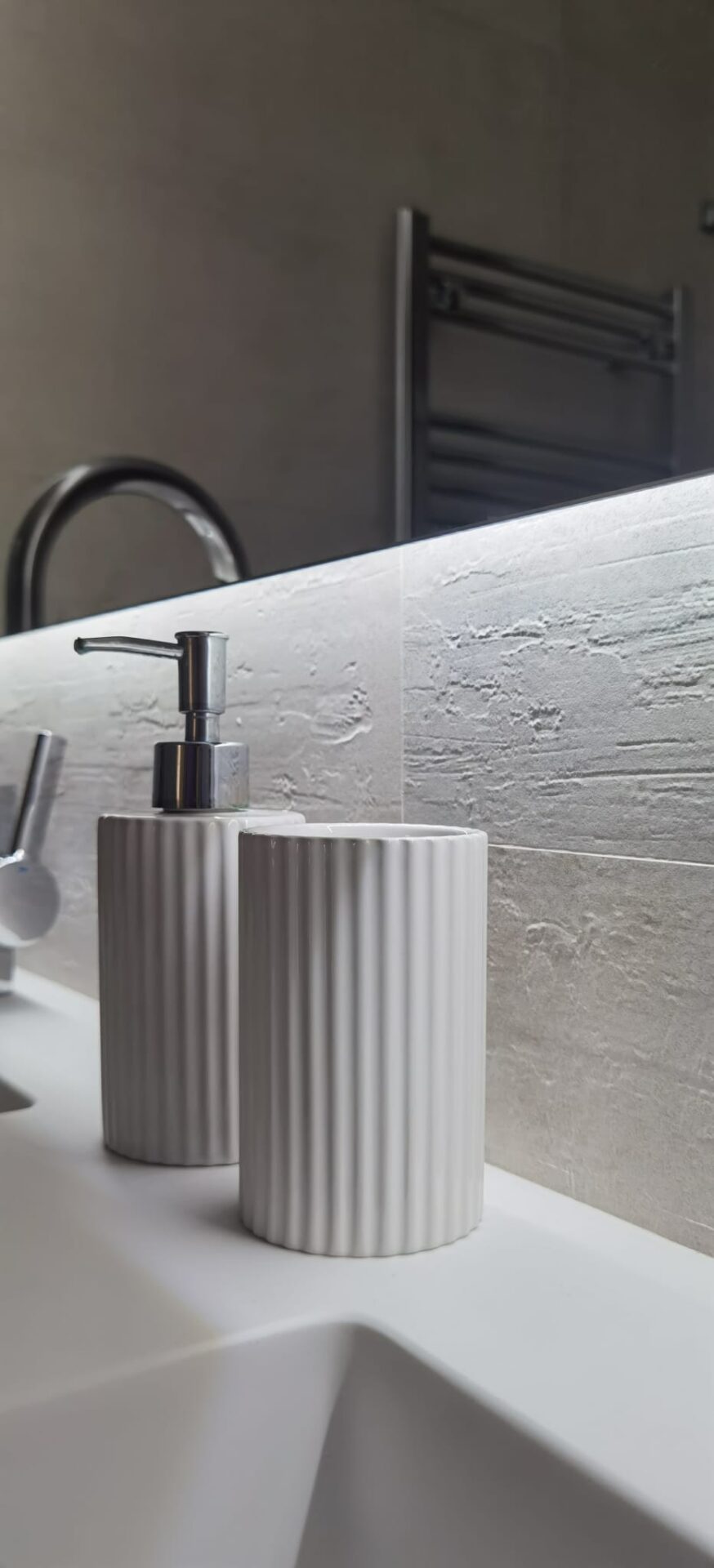 Detalle de grifería negra y radiador toallero en baño · reforma Pº Marítimo Rey de España 3 (Fuengirola) por Klic Arquitectos
