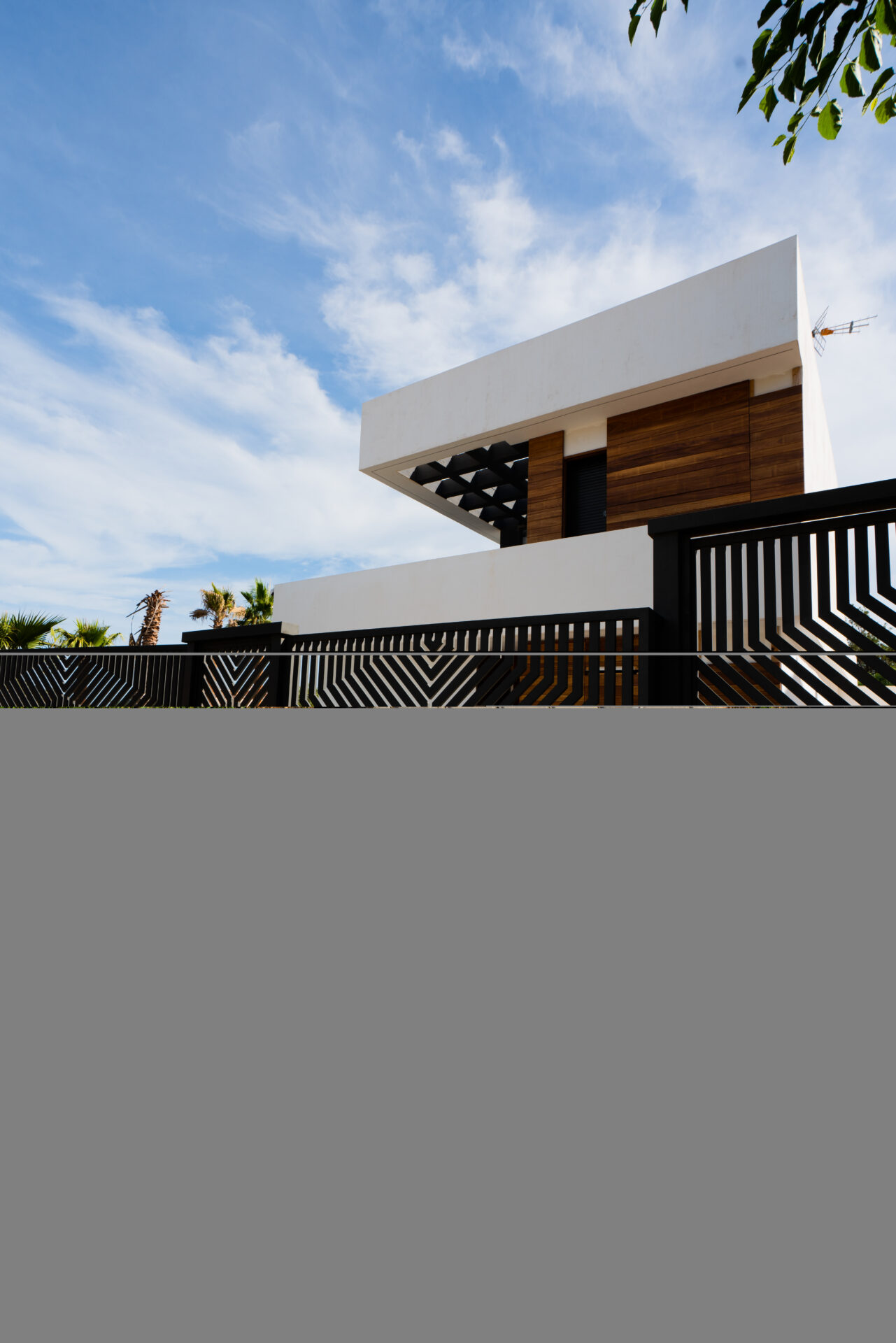 Vista exterior de Casa Maravillas con cipreses y piscina en Benalmádena Costa (Málaga), proyecto de Klic Arquitectos
