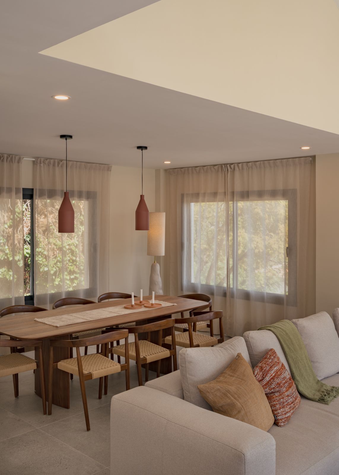 Comedor de Casa Aroa con lámparas suspendidas y mesa de madera, vivienda en Marbella por Klic Arquitectos