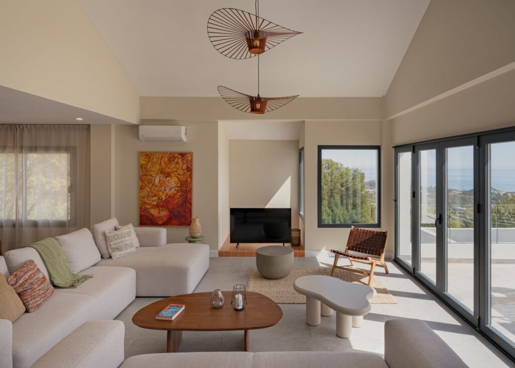 Wohnzimmer mit doppelter Höhe und Leuchte von Casa Aroa, Pinares de San Antón (Málaga) von Klic Arquitectos