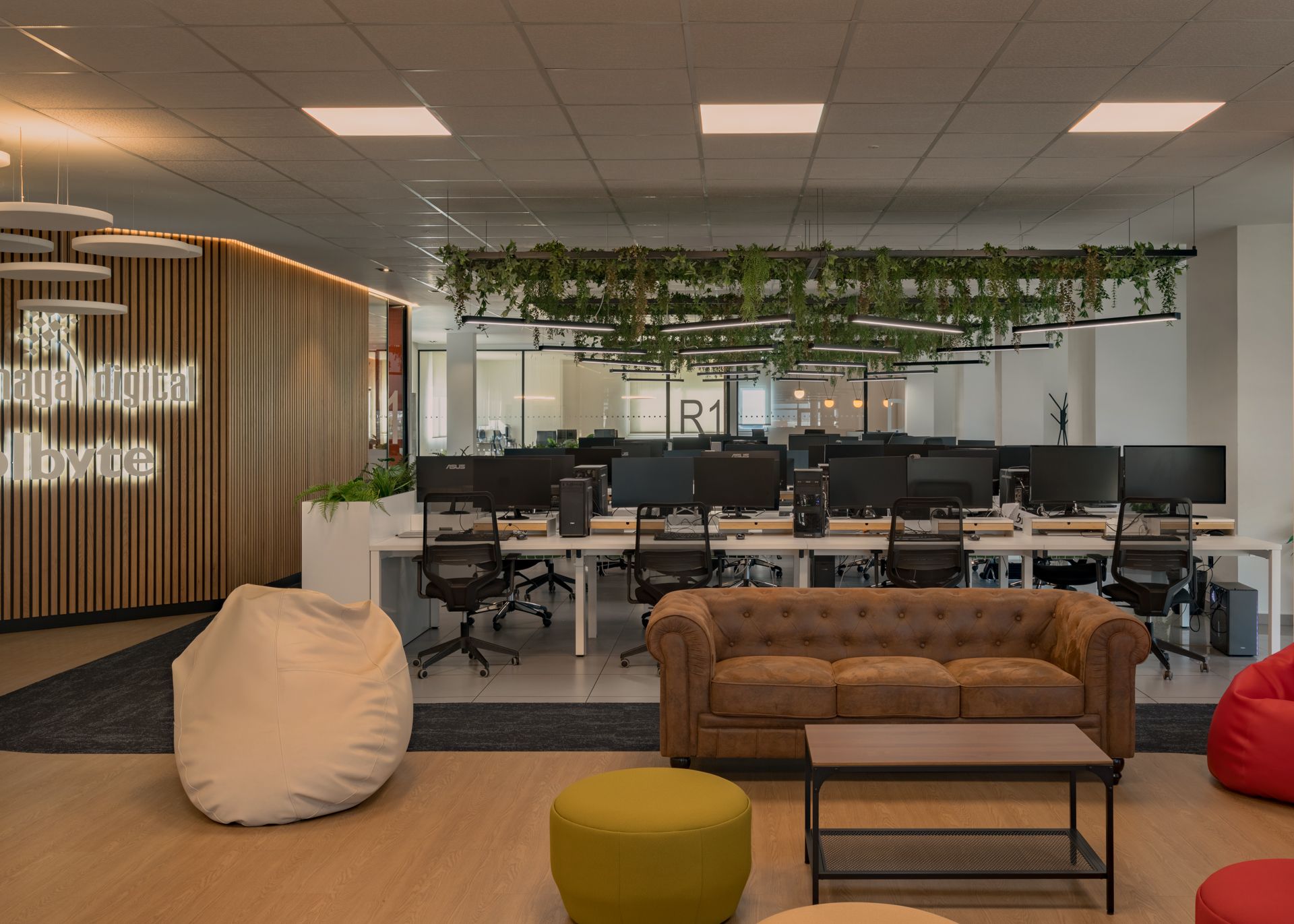 Open space con sala R1 y sofá chesterfield · oficinas Solbyte en el Polígono Industrial Guadalhorce, Málaga · diseño de Klic Arquitectos
