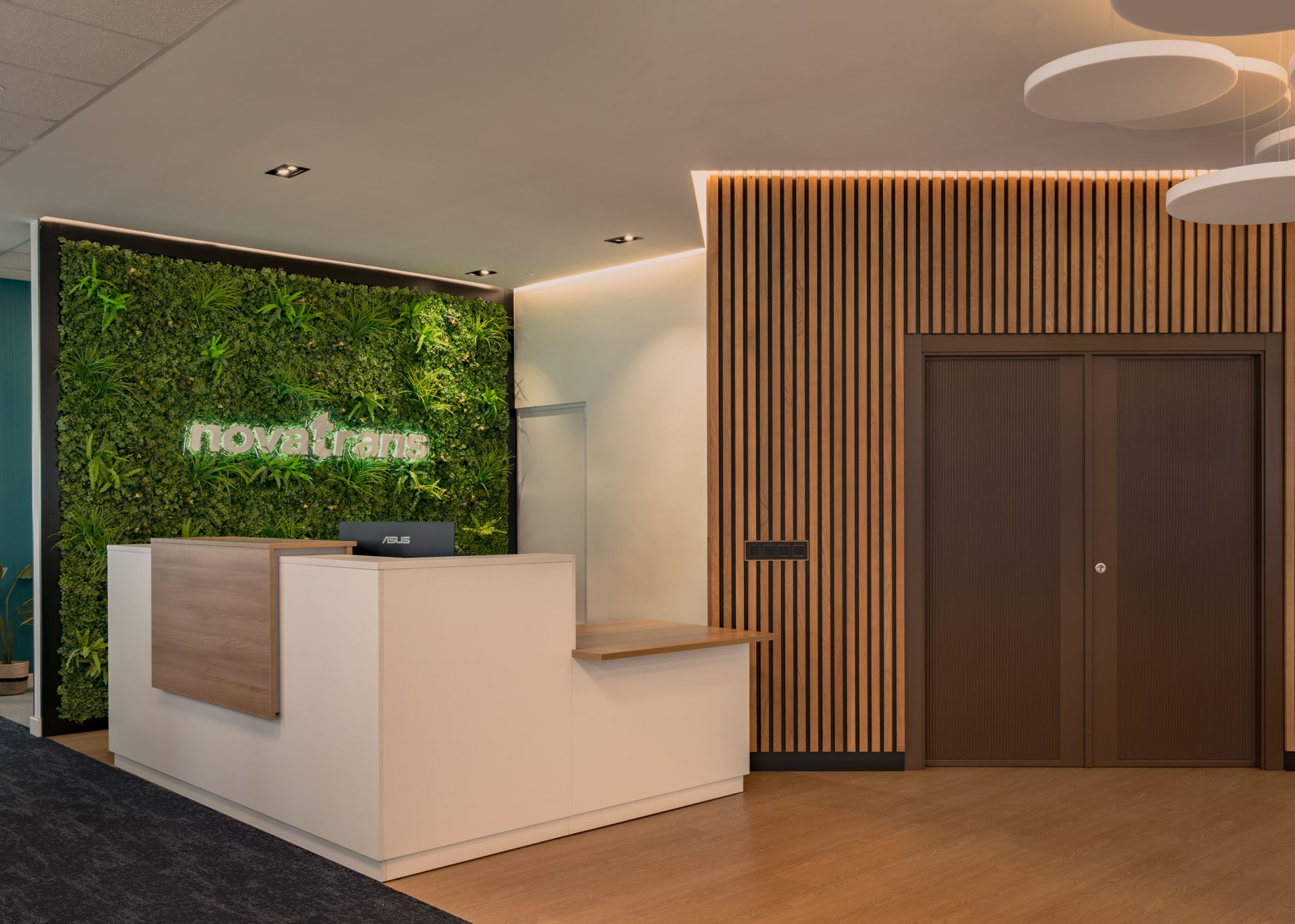 Recepción con mostrador y jardín vertical · oficinas Solbyte en el Polígono Industrial Guadalhorce, Málaga · diseño de Klic Arquitectos